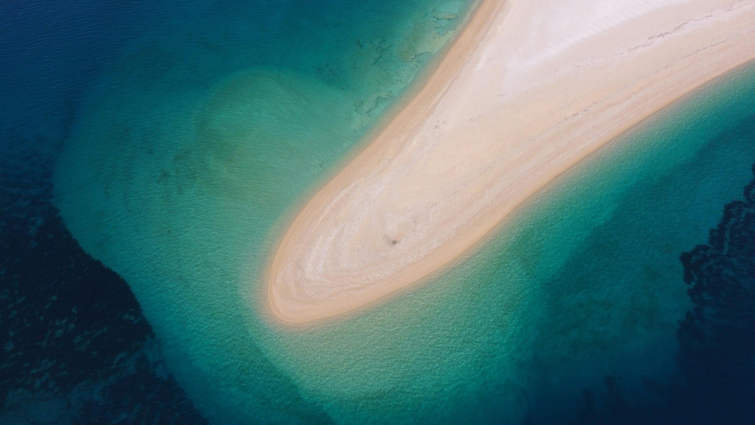 Stunning aerial view of Zlatni Rat's unique sandbar beach in Croatia, surrounded by crystal clear water.
