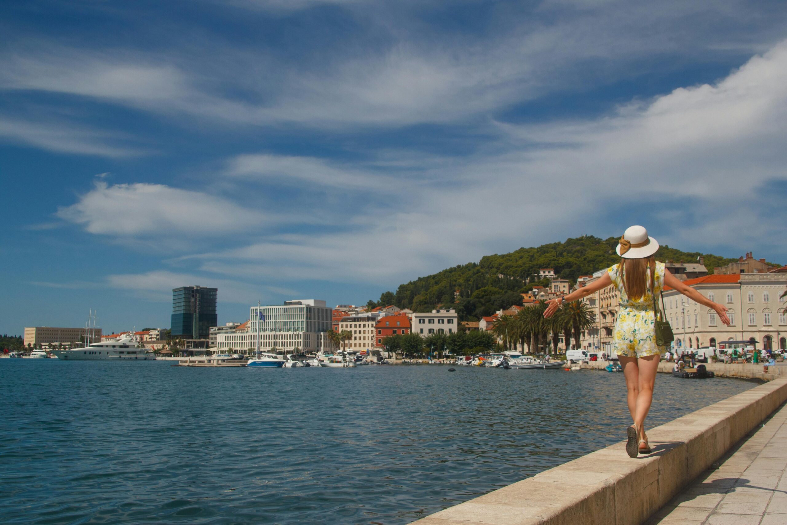A tourist walks along the scenic waterfront promenade in Split, Croatia.